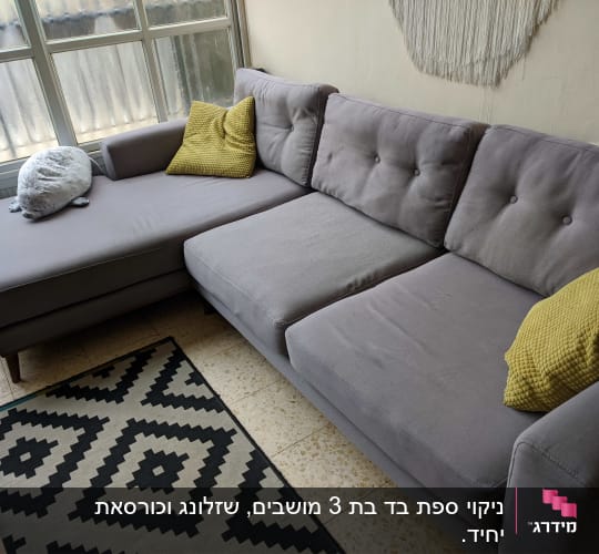 ספה אפורה עם כריות צהובות בחדר מואר